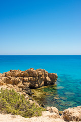 Fototapeta na wymiar colorful pristine nature of the coast of Cyprus cape cavo greco with clear blue water and yellow rocks