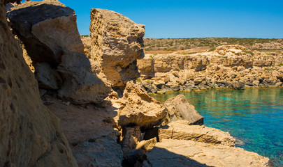  colorful pristine nature of the coast of Cyprus cape cavo greco with clear blue water and yellow rocks