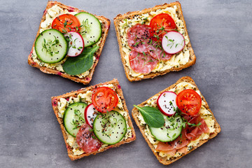 Sandwiches with cream cheese, vegetables and salami.