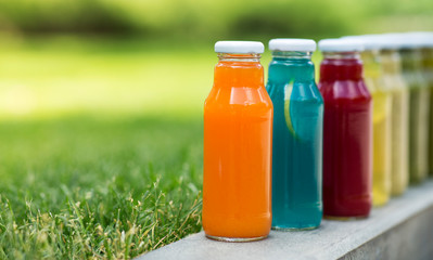 Set of natural detox cocktails in glass bottles in park zone