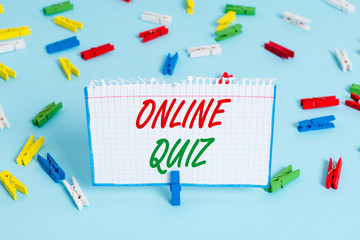 Text sign showing Online Quiz. Business photo showcasing game or a mind sport that are published on the Internet Colored clothespin papers empty reminder blue floor background office pin