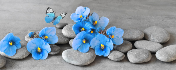 Panele Szklane  Kamienie Zen i fioletowe kwiaty na szarym tle.