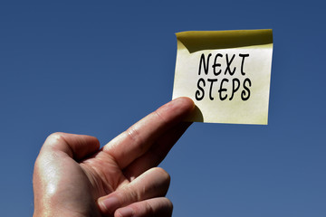 Conceptual hand writing showing Next Steps. Concept meaning something you do or plan after you ve finished something else Square paper piece notation stick to textured glass window