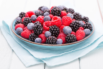 Fresh raspberries in a plate on a  vintage background.