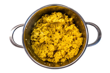 cooked steamed orange quinoa grits in a pan isolated on white background