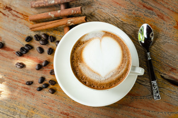 Latte coffee cup and coffee beans on the table wooden background. Top view