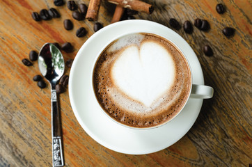 Latte coffee cup and coffee beans on the table wooden background. Top view