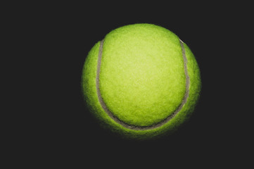 Green tennis ball isolated on black. sport equipment