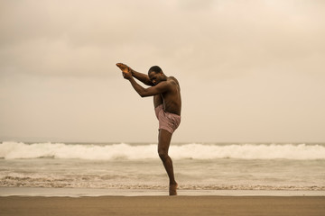 Fototapeta na wymiar dramatic contemporary dance choreographer doing ballet beach workout, young attractive and athletic afro black American man dancing on sunrise