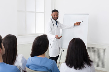 Obraz premium African-american cardiologist giving information to interns at seminar