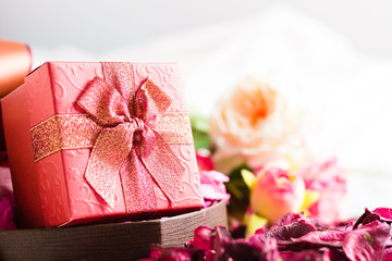 Beautiful​ red gift box with blurred background of roses