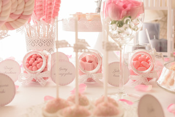 Various sweets on a lovely pastel pink candy bar at the wedding party