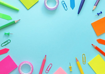 Colorful school items as a frame on blue background. Flat lay, top view. Back to school concept