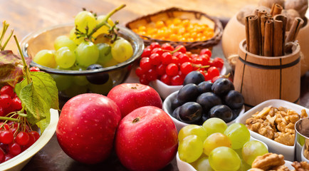 Fototapeta na wymiar Berries and leaves of viburnum, sea buckthorn, pumpkin, walnut, red apple, cinnamon and anise. Autumn vitamins to strengthen the immune system.