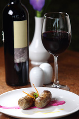 Grilled sausages accompanied by red wine.