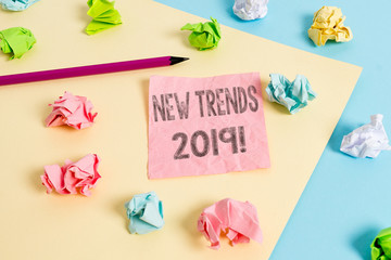 Conceptual hand writing showing New Trends 2019. Concept meaning general direction in which something is developing Colored crumpled papers empty reminder blue yellow clothespin