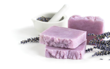 Handmade lavender bars of soap and mortar with pestle on white