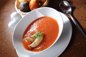 Tomato cream with purple onion and croutons.