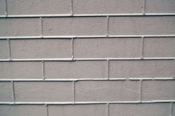 Naklejka premium The wall is made of masonry. Bricks of gray pink color on a front wall.