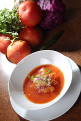 Tomato cream with purple onion and croutons.