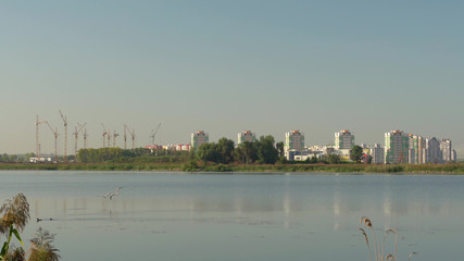 Obraz premium Building crane and buildings under construction against evening sky,