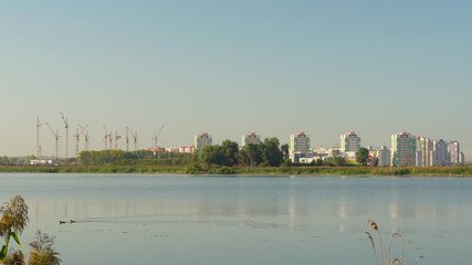 Building crane and buildings under construction against evening sky,