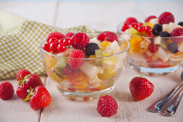 salad with fresh fruits and berries on a bowls on the concreate background