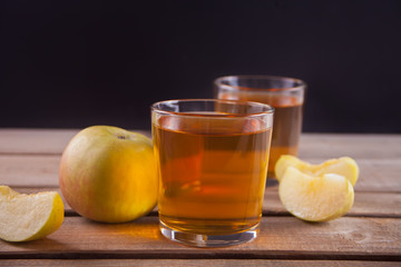 Apple juice and apples on wooden table. Selective focus