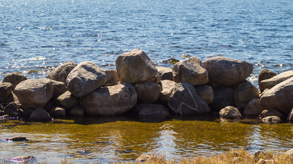 Dam from stones. dyke made from natural materials. pile of rocks in water