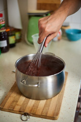 Preparing homemade chocolate pudding, closeup on hands