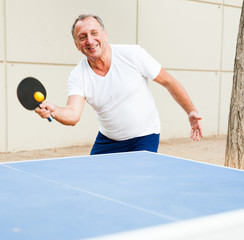 mature man starts a party at ping pong at outdoor