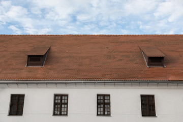 White wall, wooden windows, shingle roof