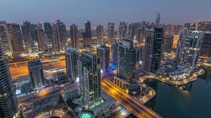 Fototapeta na wymiar Aerial top view of Dubai Marina night to day timelapse. Modern towers and traffic on the road