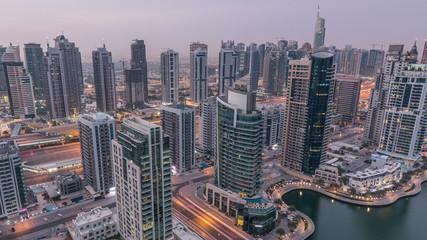 Fototapeta na wymiar Aerial top view of Dubai Marina night to day timelapse. Modern towers and traffic on the road