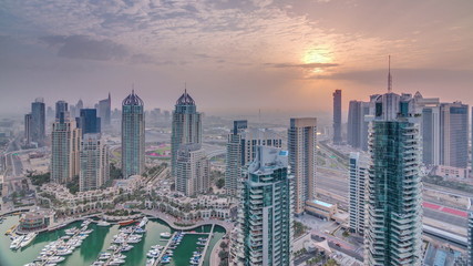 Aerial top view of sunrise in Dubai Marina timelapse. Modern towers and traffic on the road