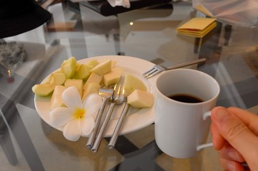 Snack time with fruits and plumeria decoration. Snack dish on a table with forks.