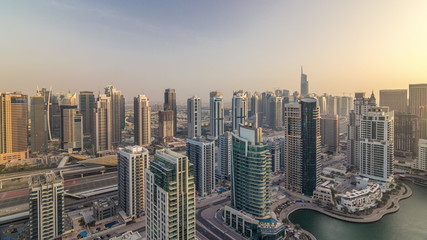 Aerial top view of Dubai Marina evening timelapse. Modern towers and traffic on the road