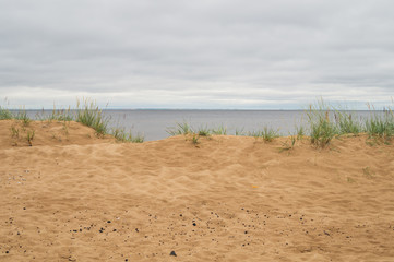 Sand beach in the bay under cloudy sky