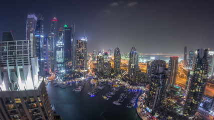 Obraz premium Aerial top view of Dubai Marina night timelapse. Modern towers and traffic on the road