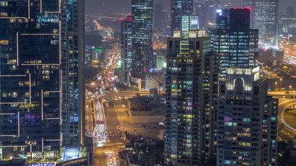 Aerial top view of Dubai Marina night timelapse. Modern towers and traffic on the road