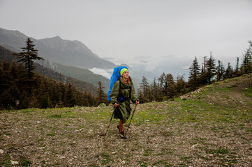 Female hiker with backpack walks on plateau