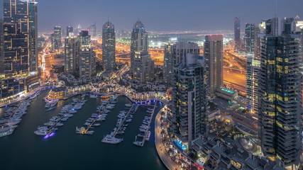 Fototapeta na wymiar Aerial top view of Dubai Marina day to night timelapse. Modern towers and traffic on the road