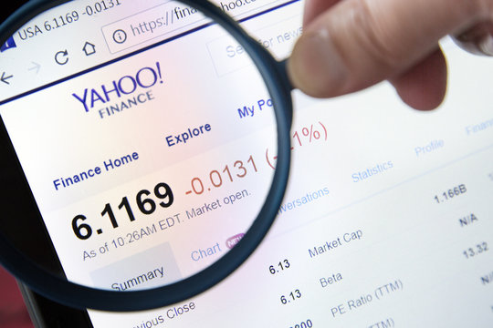Paris, France - October 19, 2017 : Finance yahoo website homepage under a magnifying glass. Finance yahoo logo visible.