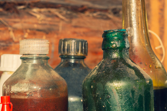 Old glass bottles with technical fluids in workshop