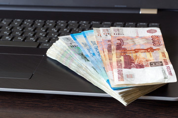 Stack of russian rubles lay on laptop keyboard