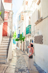 Fototapeta na wymiar Girl tourist walks outdoors in narrow street