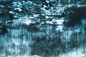 Snow covered houses with gardens in winter. wooden houses in forest aerial view. rural landscape