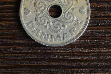 Danish coin on a wooden background. krone from Denmark close up. coin with hole