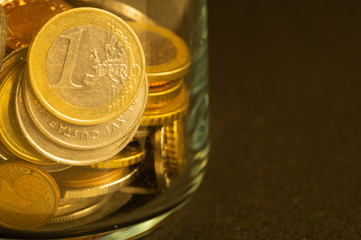 Coins of the various countries in a glass jar. metal coins of different denominations. finance background