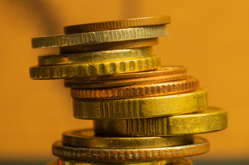 Unstable stack of different coins close up